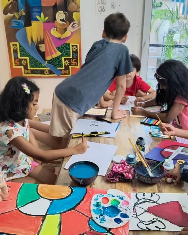 Our studio buzzing with creative energy during a painting class. The space is set up with large tables that allow for collaborative and individual work, with plenty of room for kids to spread out and create.