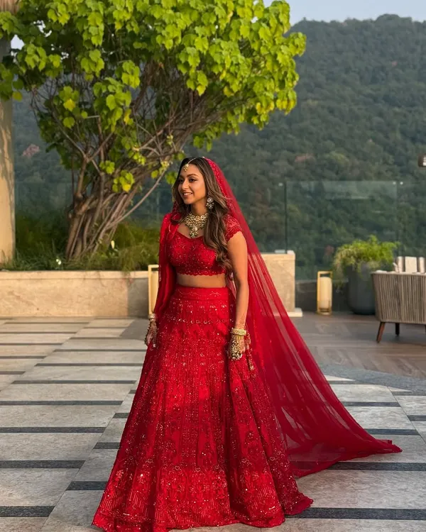 A full-length view of this stunning bride in her monochrome red lehenga at the Hyatt Regency Dehradun. The makeup was designed to be radiant and long-lasting, ensuring she looked perfect from her grand entrance to the final moments of the ceremony.