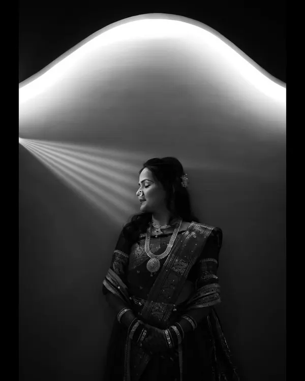 A beautiful black and white portrait using creative lighting. The bride is bathed in a soft, curved light from above, creating a serene and almost angelic image.