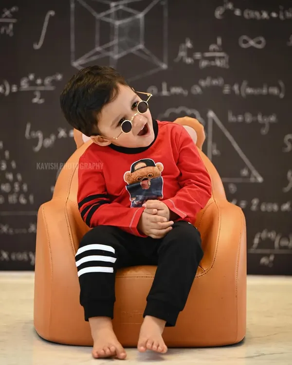 A fun and quirky kid's portrait with a 'little genius' theme, featuring a chalkboard with equations and a cool pair of glasses.