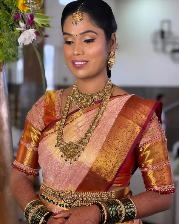 A beautiful portrait of bride Ranjitha for her Muhurtham. Her look is defined by classic temple jewellery, a neatly draped Kanchipuram saree, and makeup that highlights her natural features with a soft glow and a traditional bindi.