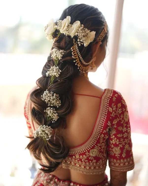 A bridal hairstyle should be a work of art. Here, I've created an intricate floral braid for a Pahadi bride, weaving in fresh flowers to create a unique and stunning look from every angle.