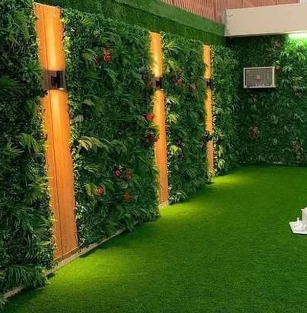 This is how you transform an outdoor or semi-outdoor space. I covered the walls with dense artificial greenery and integrated vertical wood-paneled lighting, turning a plain area into a private, illuminated garden oasis.