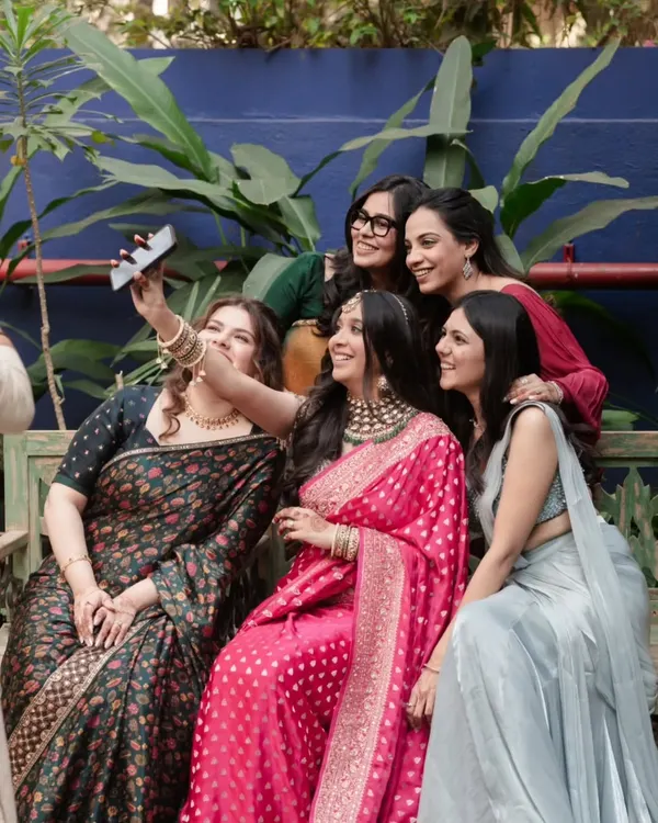 The bride and her bridesmaids gather for a happy selfie, a perfect, unposed moment capturing the joy and friendship of the bride tribe.