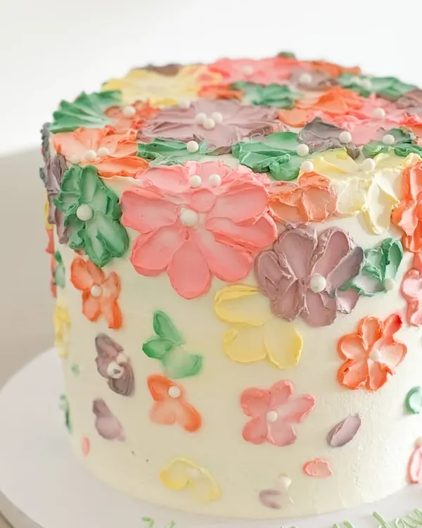 Indulge in the velvety texture and rich flavors of this vegan masterpiece. This cake, covered in hand-piped flowers, is a beautiful example of my custom vegan creations.