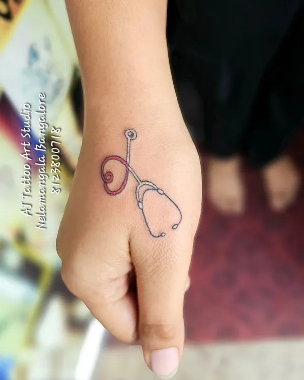 A tiny stethoscope tattoo on the thumb, a perfect design for a doctor or medical professional.