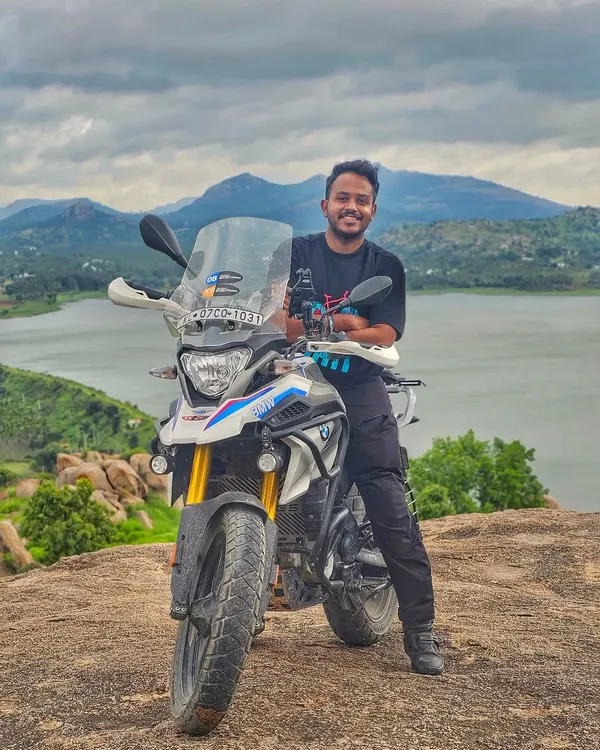 A rider and his BMW G310GS adventure bike posing against the backdrop of a beautiful lake. We welcome riders of all types of motorcycles, from adventure tourers to sportbikes.