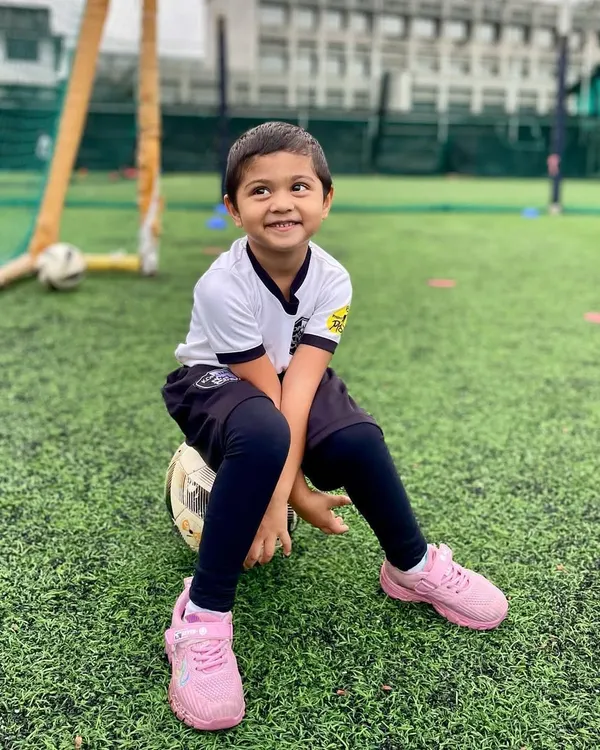 A happy player from our U4 batch takes a break, sitting on his football with a big smile. This image captures the pure, simple joy of our youngest program.