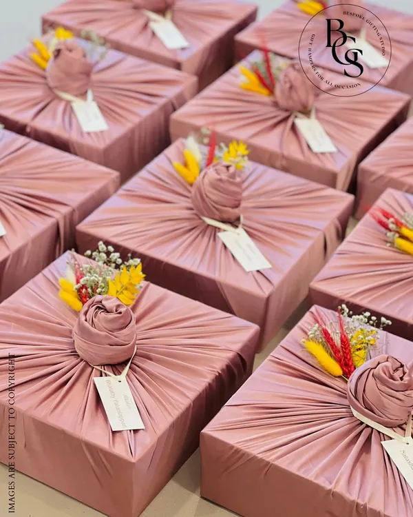 Fabric wrapping adds a layer of luxury and sustainability to any gift. These dusty rose boxes, wrapped in pleated fabric and adorned with dried flowers, are a perfect example of how to make a gift feel exceptionally special and unique.