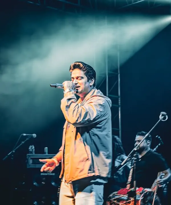 This edited shot of Amit Prakash Mishra focuses on creating a specific mood with color grading, capturing an intense moment of his performance under a single spotlight.