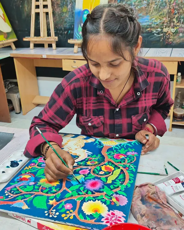 A student painting a detailed design on a ceramic piece. Our classes combine both sculpting and painting techniques to create finished ceramic artworks.