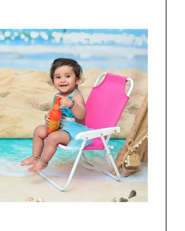 A happy baby girl enjoys her day at the "beach" in my studio. Sitting on a pink deck chair with a toy bottle, her smile is as bright as the summer sun in this fun themed shoot.