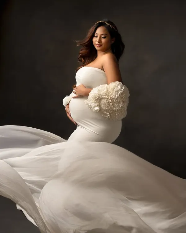 An angelic vision in white. This portrait is all about capturing the serenity and grace of motherhood with a flowing gown that feels as soft and gentle as the moment itself.