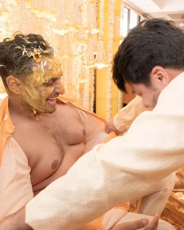 This is what a haldi is all about. The groom's kurta being torn off by his friends is a moment of pure, unscripted fun that I love to capture.