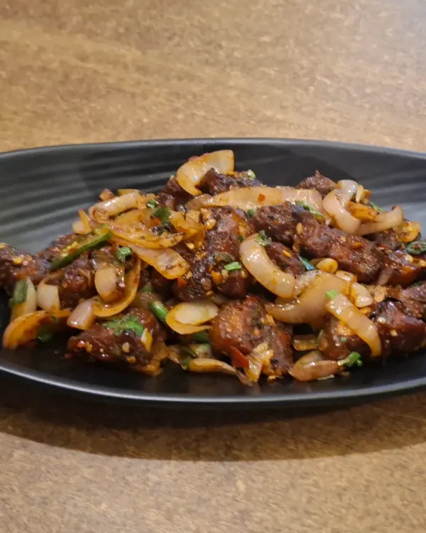 Our spicy Pork Dry Fry is a customer favourite. Tender pieces of pork are fried with onions, ginger, garlic, and fiery chillies for a perfect starter or side dish.