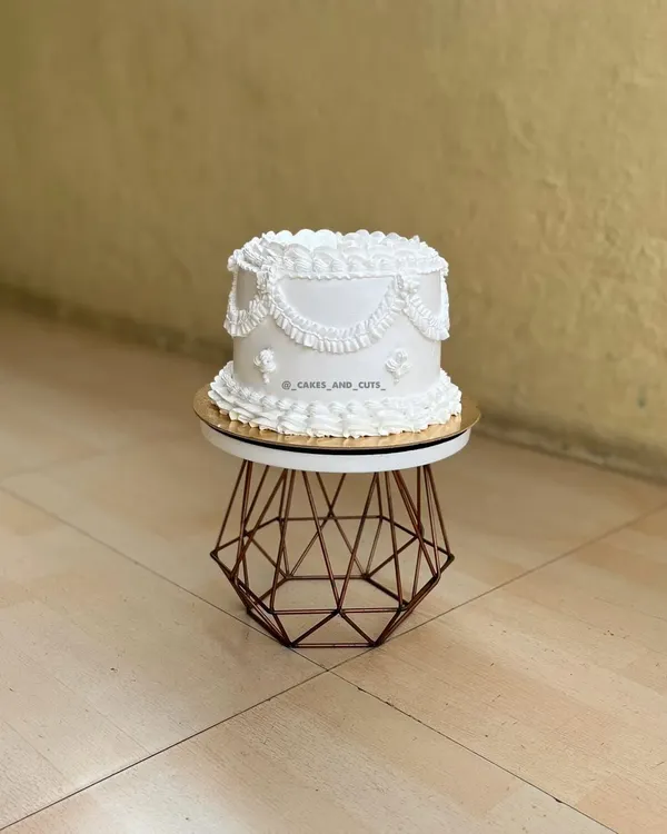 A beautiful all-white vintage cake featuring classic swag piping. This is a perfect example of the skills we teach in our piping-focused workshops.