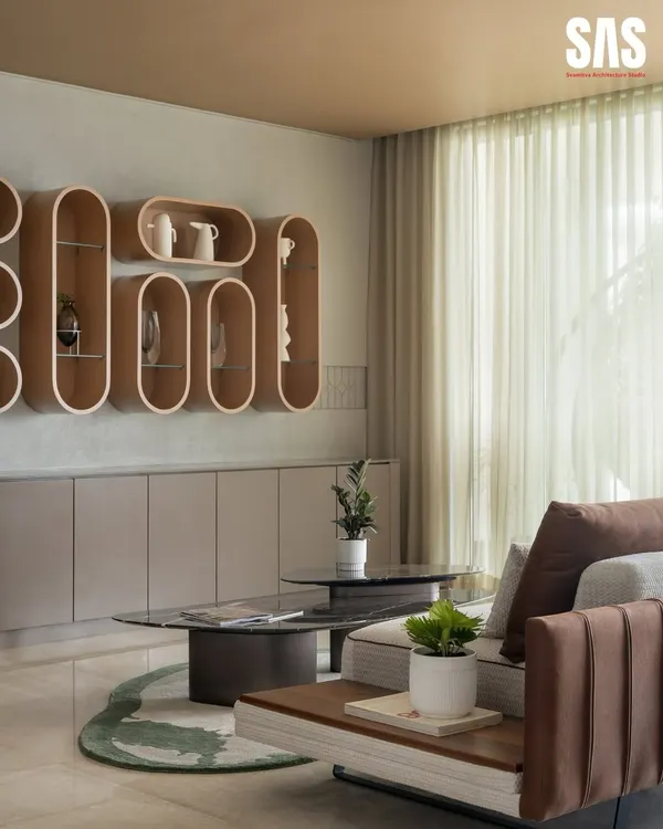 A detail from the Embassy Lake Terraces living room, where sculptural wooden shelves create a unique display. The soft, neutral tones and sheer curtains enhance the feeling of light and space, making it a perfect corner for quiet reflection.