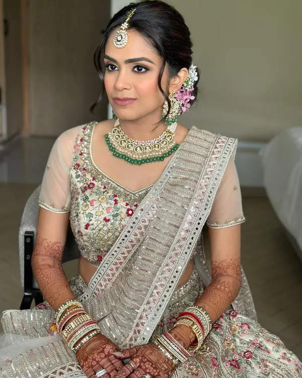 Flushed lids, a luminous base, and neutral rose lips. This look is for the bride who dreams of a magical, romantic canvas for her wedding day, with soft florals tucked into her hair.