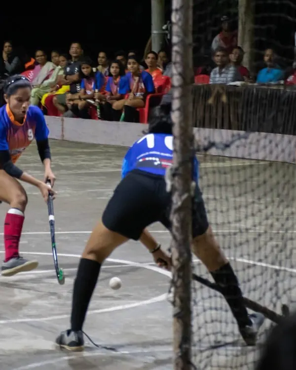 An intense moment from a girls' rink hockey exhibition match, with a player taking a shot on goal as the keeper prepares to make a save. This showcases the high skill level of our female players.