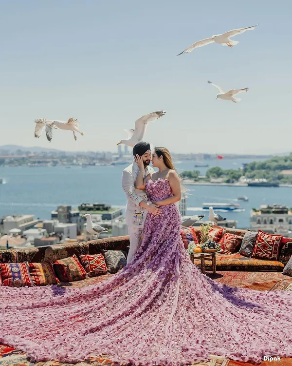 A breathtaking pre-wedding portrait in Turkey, with the bride's magnificent floral gown cascading over a rooftop overlooking the Bosphorus as seagulls fly by. This is the kind of epic, romantic photography I specialize in.
