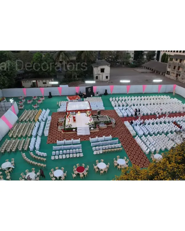 A high-angle view of an engagement ceremony setup on a large ground. This shows the organized seating arrangement for guests and the central mandap where the main ceremony takes place.