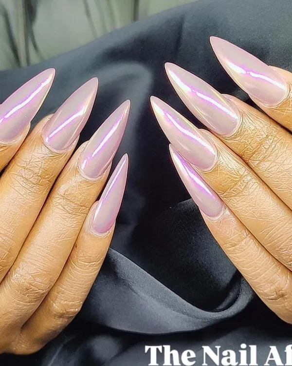 A dramatic set of extra-long stiletto nails with an iridescent pink "unicorn" chrome finish that shifts in the light.