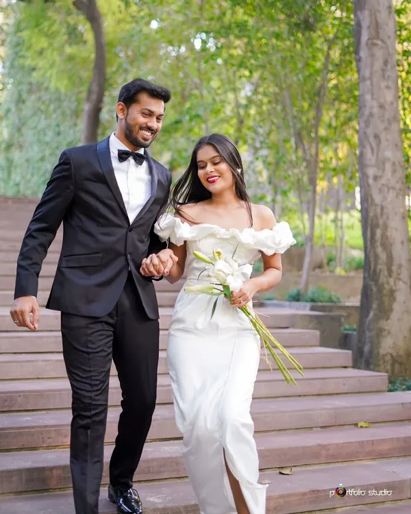 A beautiful, candid shot of a couple in formal attire walking down steps in a lush park. Their smiles and easy movement show the relaxed and happy atmosphere I create during my shoots.