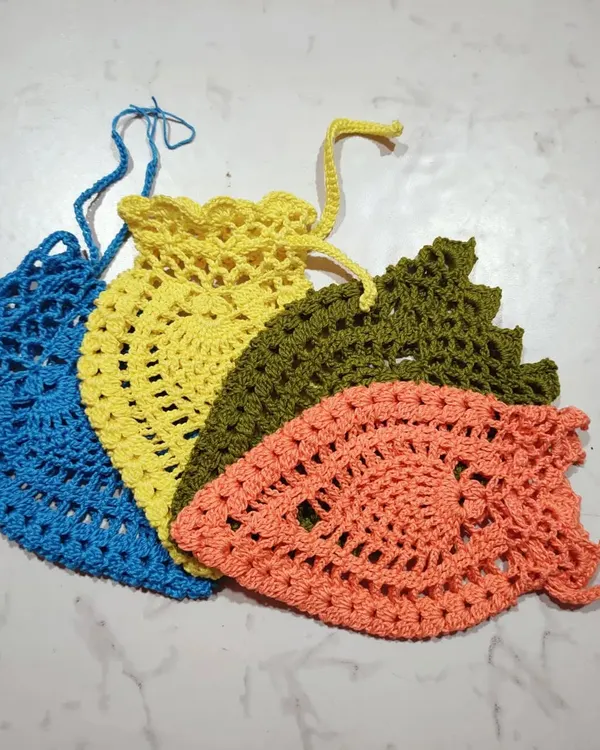 A collection of my handmade pineapple pouches in different colors. The lacy pattern is lightweight, and the drawstring closure keeps small items secure.