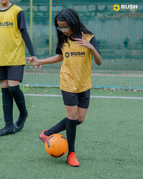 A young female player with excellent focus and ball control during a drill.