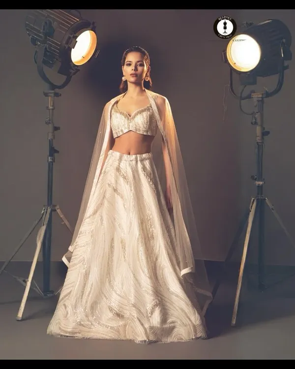This ivory and silver lehenga embodies modern bridal elegance. I designed it for the bride who seeks a timeless look with intricate, shimmering hand-embroidery and a graceful silhouette.