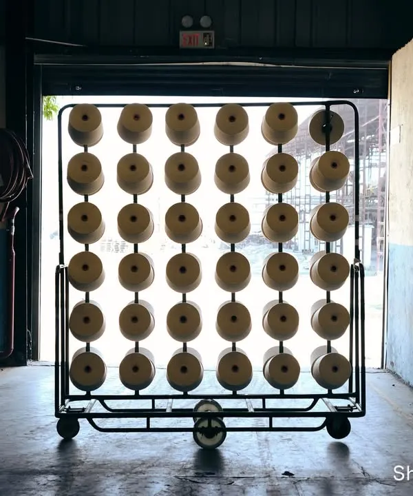 Before the color, there is form. This shot captures the raw potential of yarn cones in a textile factory, finding beauty in the industrial repetition and the raw material of the craft.