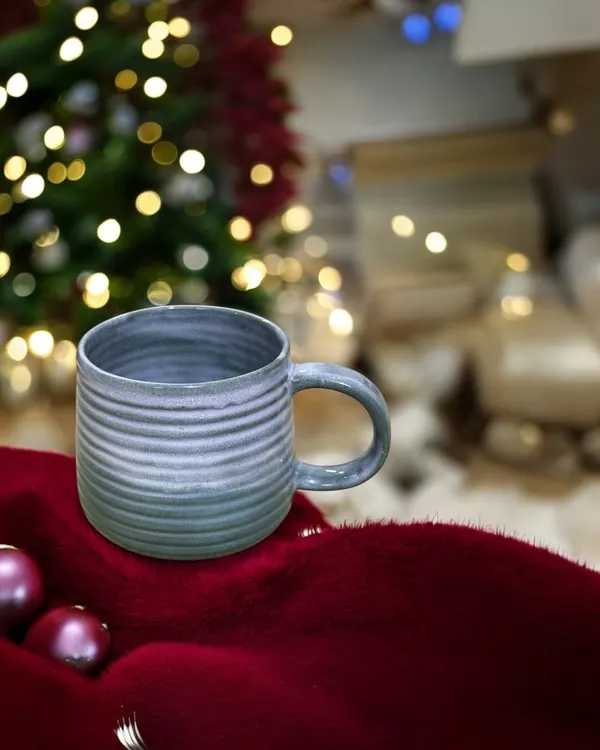 A hand-built stoneware mug with a carved texture and a soft blue-grey glaze. A handmade mug makes your morning coffee or tea feel a little more special, and they make wonderful, personal gifts.