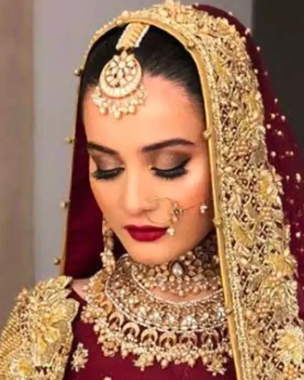 A classic bridal portrait showcasing a deep red lip and soft, smoky eyes. This timeless look is perfect for the traditional bride who wants to look regal and elegant.