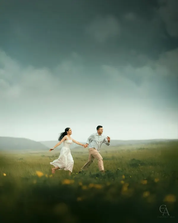 Running hand in hand through an open meadow, with the wind in her hair and a vast sky above. This candid shot is all about capturing the feeling of freedom and adventure that begins your journey together.