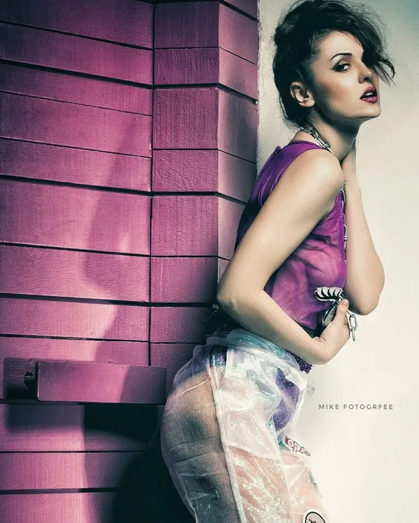 An edgy, high-fashion editorial shot using bold colors and unconventional styling. The high-contrast lighting and intense pose create a dramatic and provocative image that pushes creative boundaries.