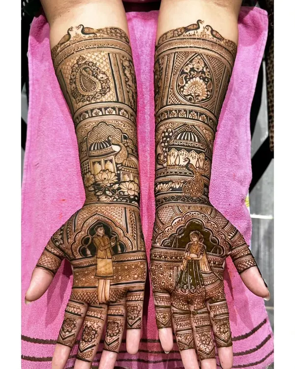 A grand and regal mehendi design for an engagement ceremony. It features portraits of the couple set against a backdrop of palace architecture, making a stunning statement.
