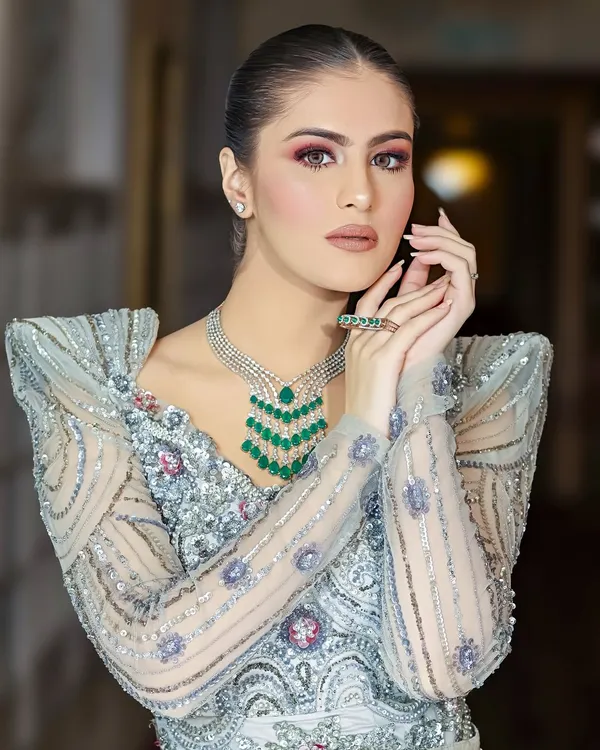 A stunning portrait showcasing a complete bridal jewelry set, including a multi-layered emerald necklace and matching ring. The lighting is precisely controlled to make every gem and detail stand out.