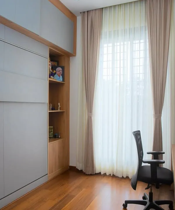 A perfectly integrated workspace where functionality meets elegance. This home office features a Murphy bed hidden behind the grey panels, allowing the room to double as a guest space.