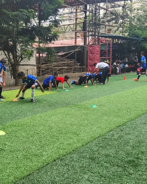 Every practice is a step toward greatness. Here, our young athletes are engaged in agility drills on the turf, building the speed and coordination needed to excel.