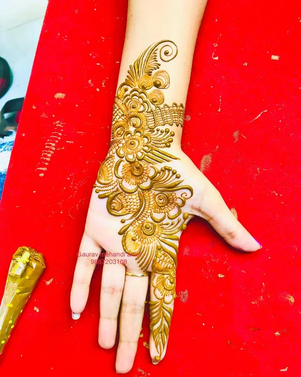 A classic Arabic "bail" or vine design. This style is elegant and quick to apply, making it a popular choice for guests at weddings, sangeets, or festivals like Eid.