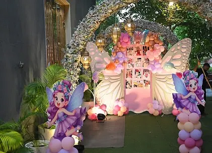 An enchanting entrance to a butterfly-themed party. We used a floral archway and life-size fairy cutouts to guide guests into a magical world.