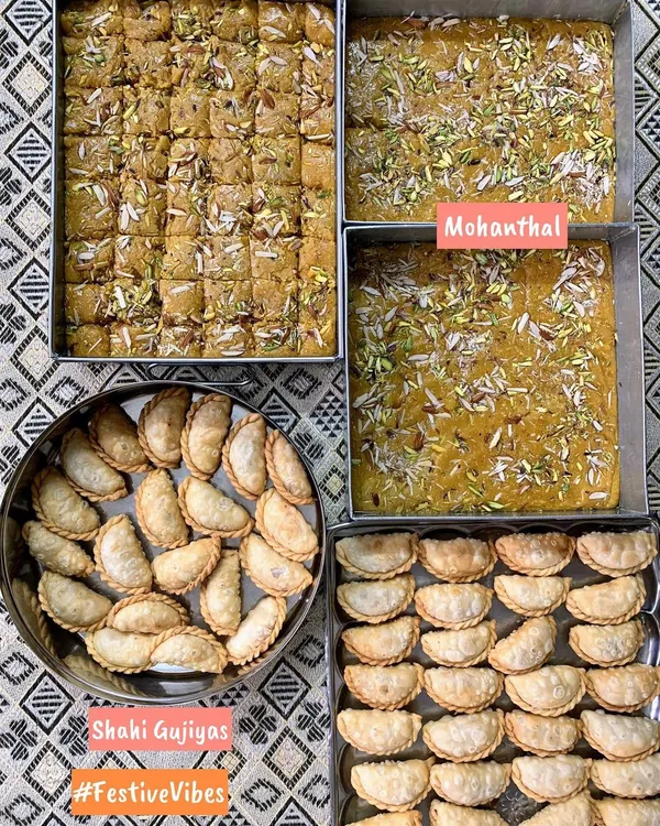 A festive spread of traditional Indian sweets, featuring trays of rich Mohanthal and perfectly shaped Shahi Gujiyas, made especially for Raksha Bandhan.