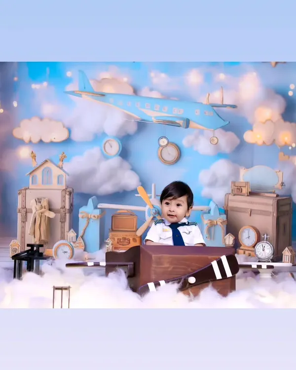 Our little pilot theme is perfect for adventurous spirits. This wide shot shows the complete setup with clouds, airplanes, and vintage travel props.