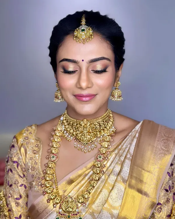 A close-up of Pranitha's Muhurtham makeup. I used airbrush techniques to create this flawless, glowing base, paired with soft gold eyeshadow and a gentle pink lip to let her natural beauty shine.