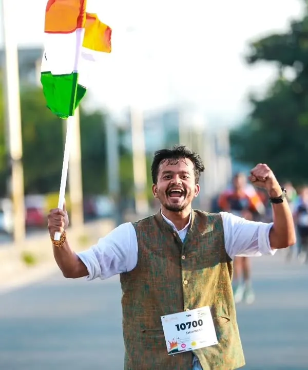 The joy and patriotism of a runner at our Freedom Run, celebrating with the Indian flag. This event is about more than just running; it's about community spirit.