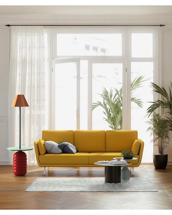 A piece from the 'Bernard and friends' collection in a bright, sunlit living room. The handcrafted wooden side table with an integrated lamp reflects our focus on natural materials and timeless, functional design.