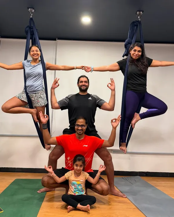 Welcome to our family bonding sessions, where yoga becomes a joyful adventure for everyone. Here, parents and children connect through playful poses, like in this fun group aerial yoga formation, creating wonderful memories together.