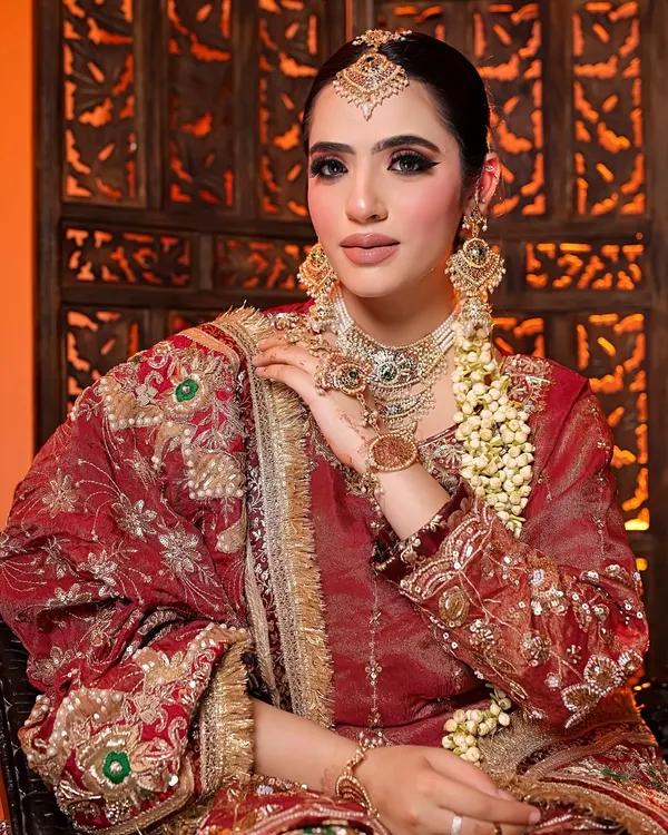 A detailed portrait of a model in a stunning red bridal lehenga, showcasing intricate jewelry and flawless makeup. This shot highlights my skill in capturing traditional beauty with a modern, high-fashion feel.