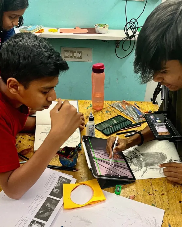 Collaboration and focus are key in the studio. Here, students work side by side, one sketching on paper and the other digitally, to master the fundamentals of drawing.