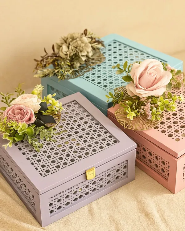 We love creating beautiful packaging that feels as special as the gift inside. This image showcases our pastel-colored, cane-detailed keepsake boxes, adorned with floral arrangements, ready to be customized for any occasion like Rakhi or a birthday.